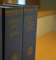 Två lagböcker med texten Sveriges rikes lag på bokryggarna