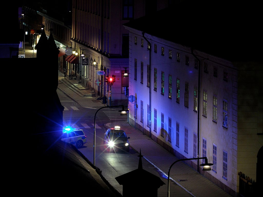 En polisbil med blåljus på utryckning i stadsmiljö. Foto: Robin Simonsson/Åklagarmyndigheten